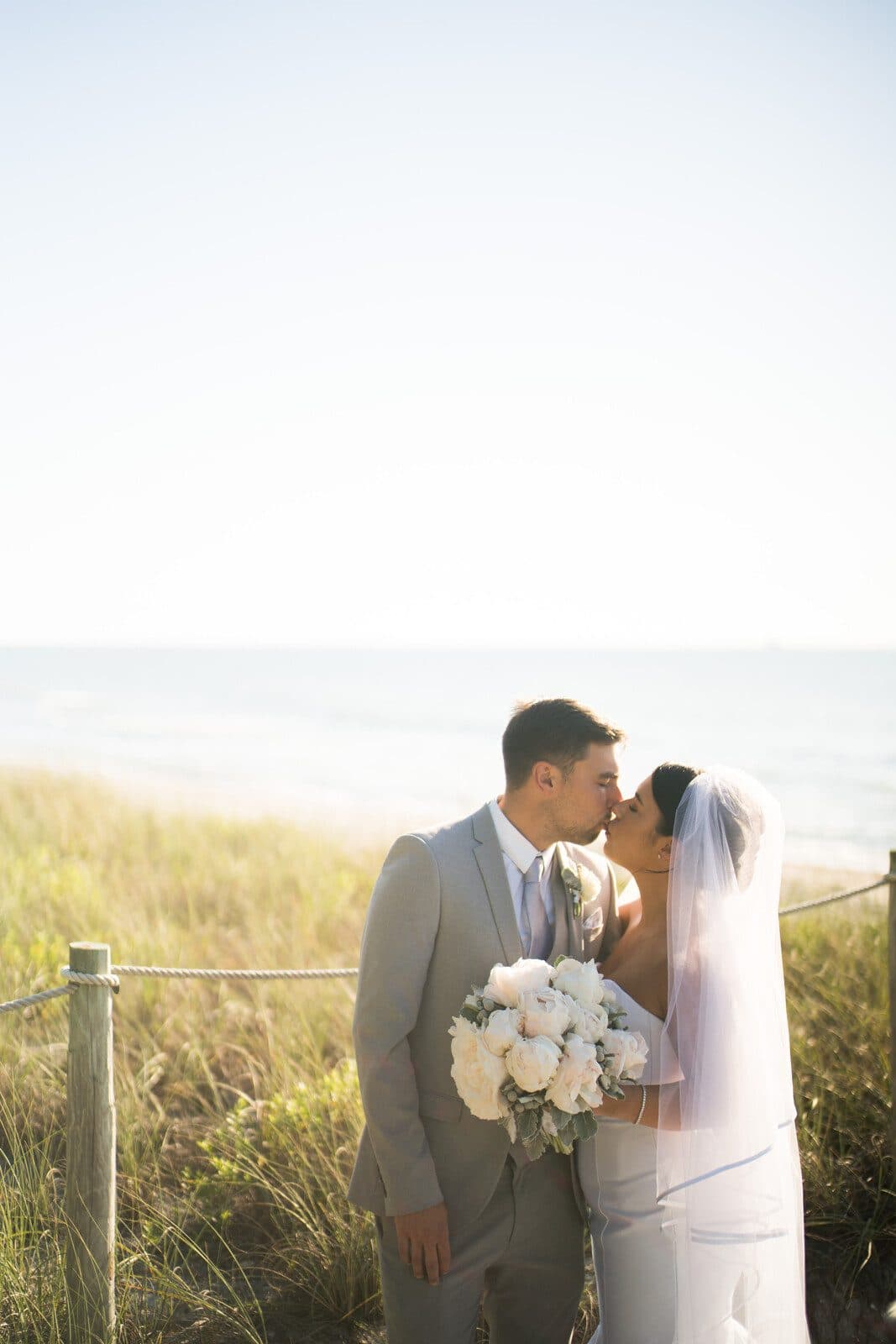A kiss at the waterline on Captiva Island, by destination wedding photographer Studio Y